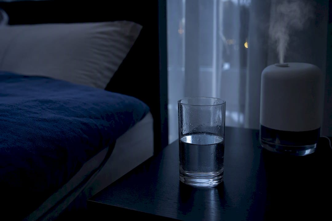 Glass of water next to humidifier mist at night